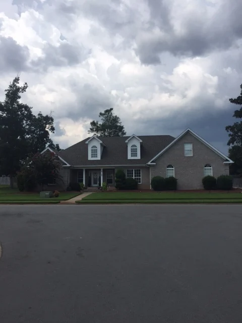 Two-story home with dormers, a front porch, and a shingle roof from CAR’s residential portfolio
