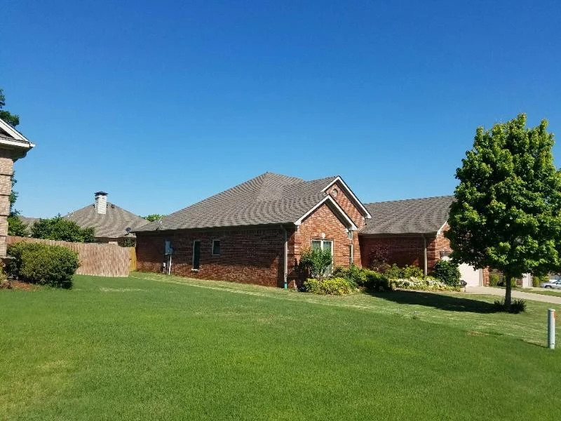Single-story brick house with a broad shingle roof and lawn from CAR’s residential portfolio